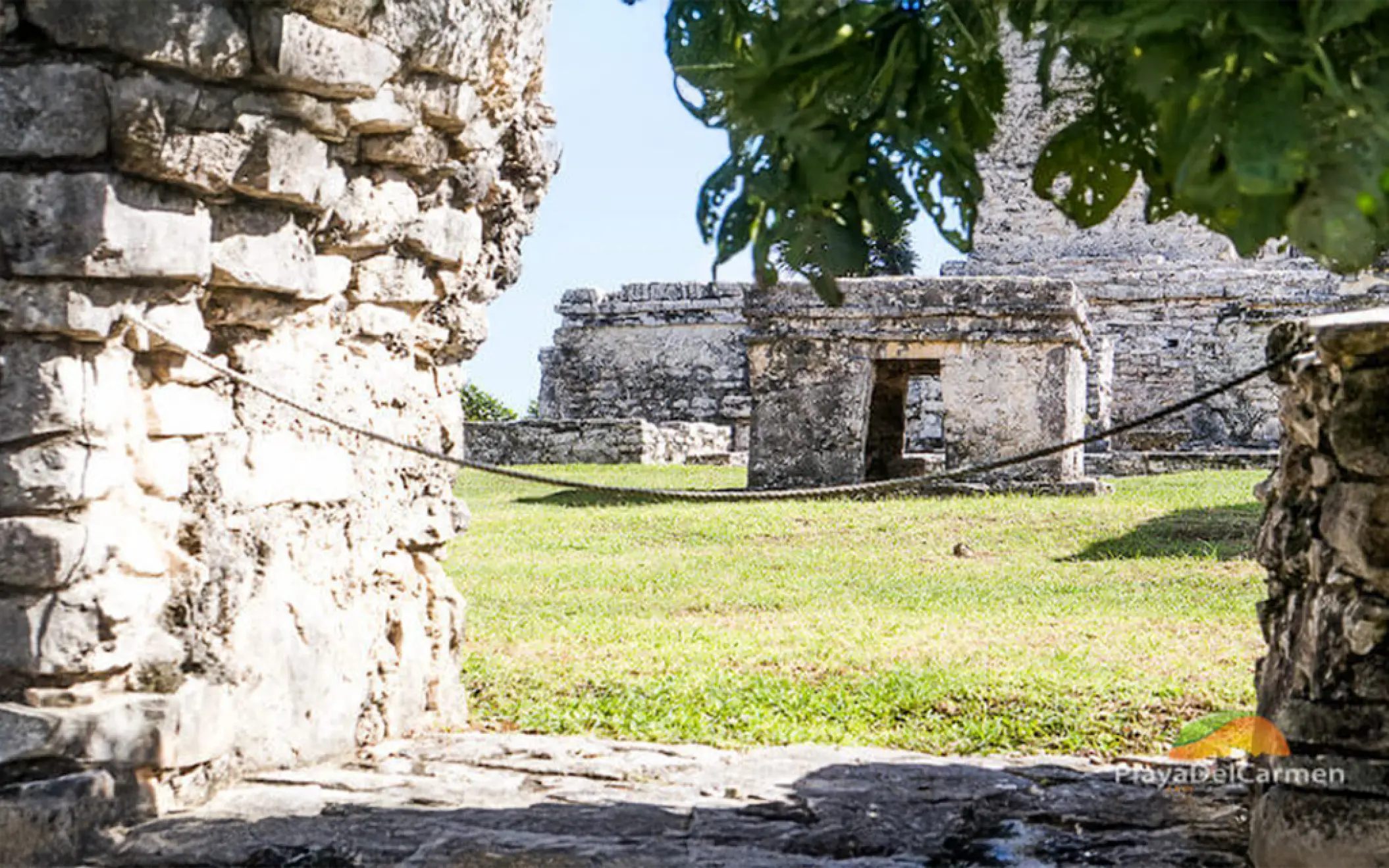 A unique view of the Tulum ruins through a stone wall, capturing the mystery of the Mayan era