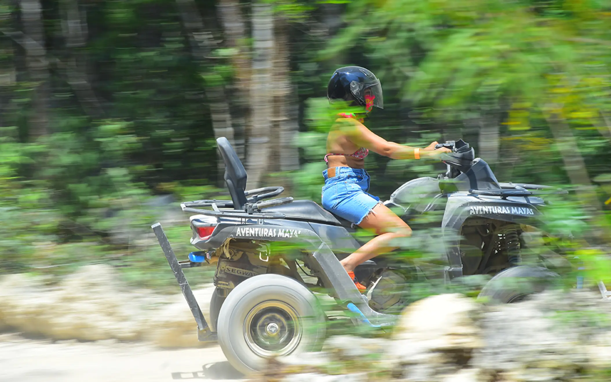 Woman riding an ATV with confidence through the dense and exciting jungle terrain of Tulum