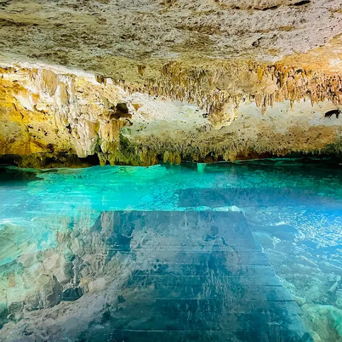 Stunning cave cenote with turquoise water and rock formations inside Xel-Há park
