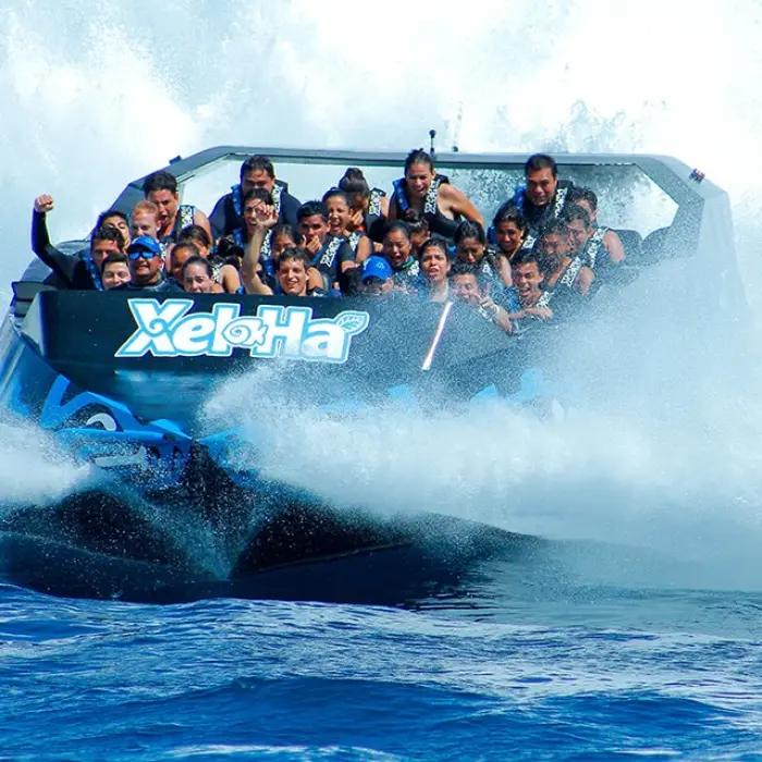 Group speeding over water on the Xel-Há jet boat ride, splashing through waves