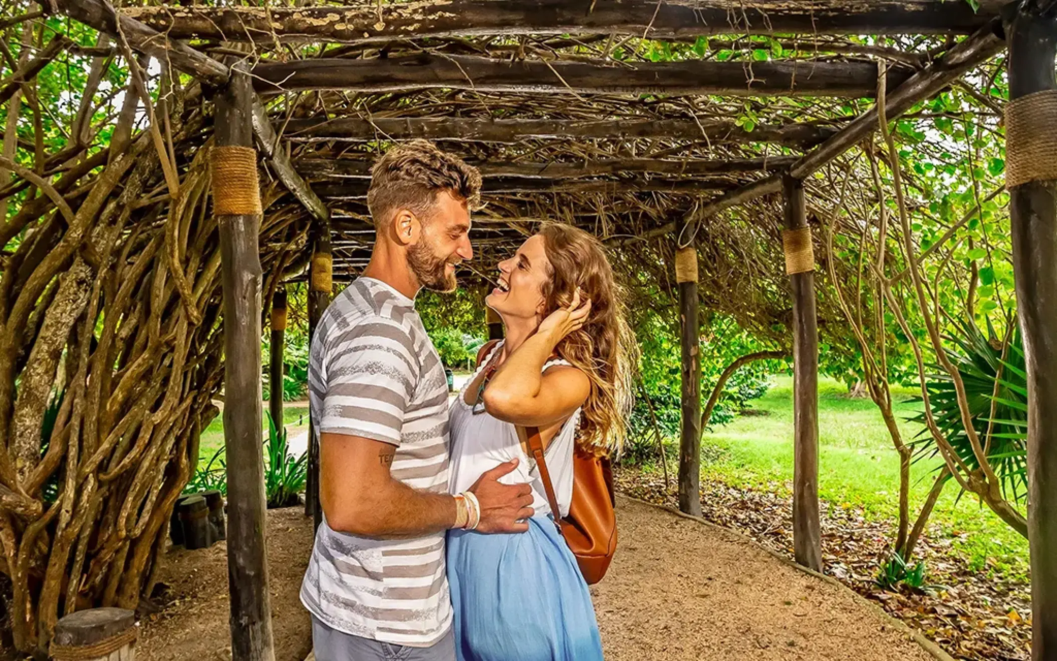 Sweet moment under a vine-covered arch at Tulum. Romantic vibes in the Riviera Maya