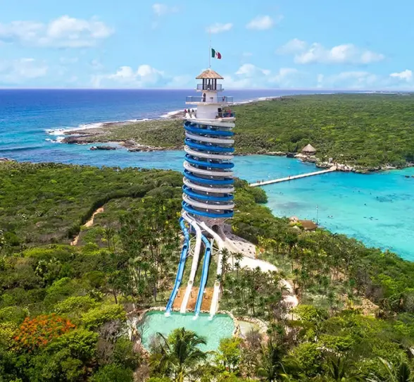 Aerial view of Xel-Há’s iconic scenic lighthouse slide surrounded by lush jungle and turquoise waters