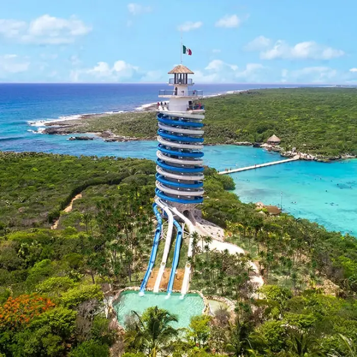 Aerial view of Xel-Há’s iconic scenic lighthouse slide surrounded by lush jungle and turquoise waters