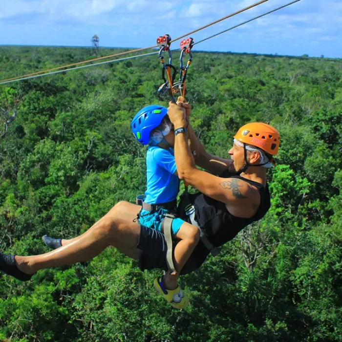 Zipline structure with safety harnesses and lush greenery in the background, available on the Tulum Xtreme Tour