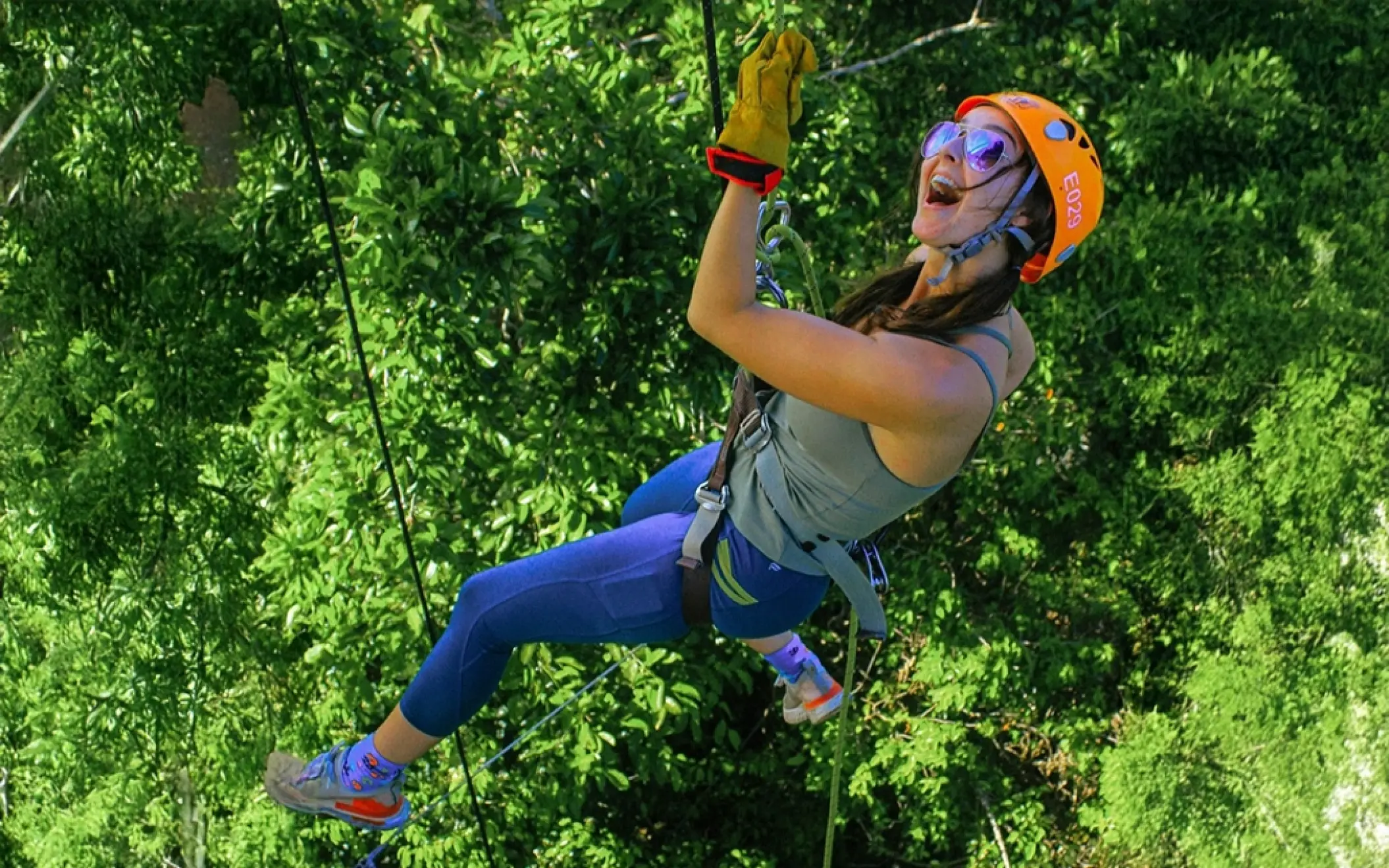 Person rappelling down a rock wall in the jungle during the Tulum Xtreme Tour