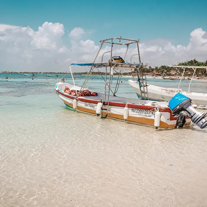 Akumal Beach boats: Several boats resting on the white sand of Akumal Beach with clear shallow water