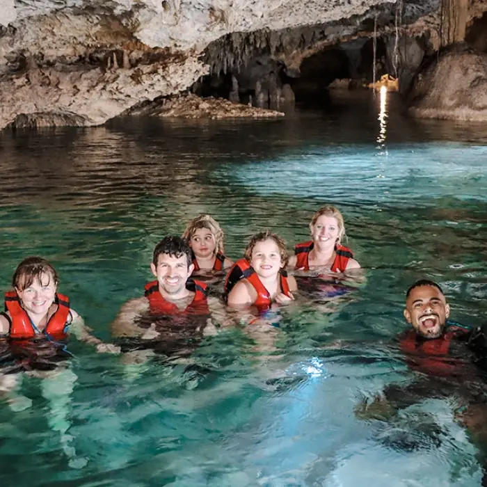 Cenote Yum Balam smiles: Happy group of people swimming in the clear, shallow water of Cenote Yum Balam