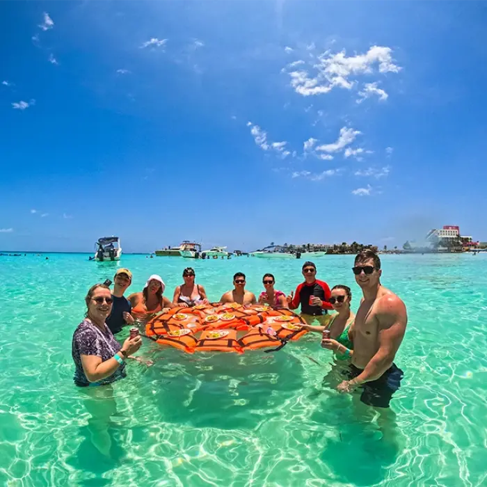 Our happy tour group enjoys fresh ceviche and drinks in the shallow turquoise waters of Isla Mujeres after their whale shark adventure.