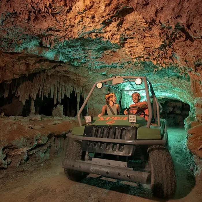 ATV driving through a glowing stalactite-filled cave