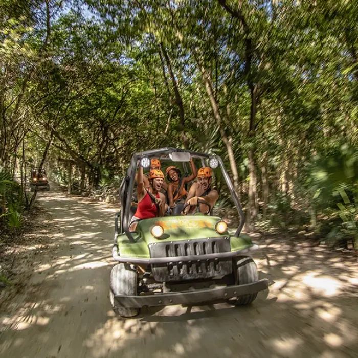 Group riding an all-terrain vehicle through the jungle trail