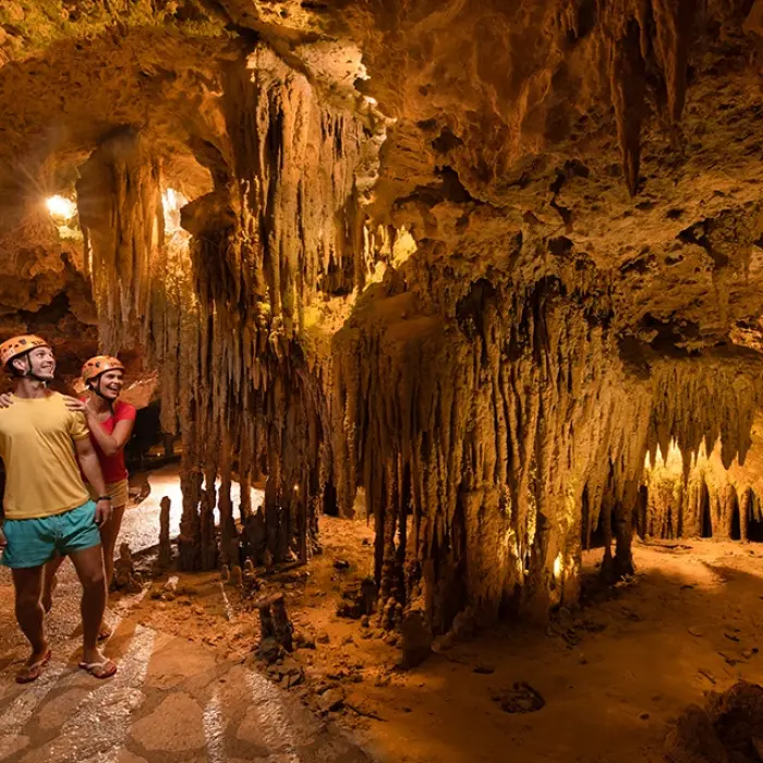 Couple walking through an epic cavern of stalactites