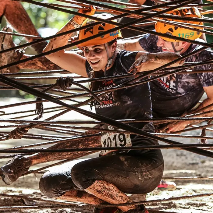 Splashing through water obstacles with big smiles and helmets on