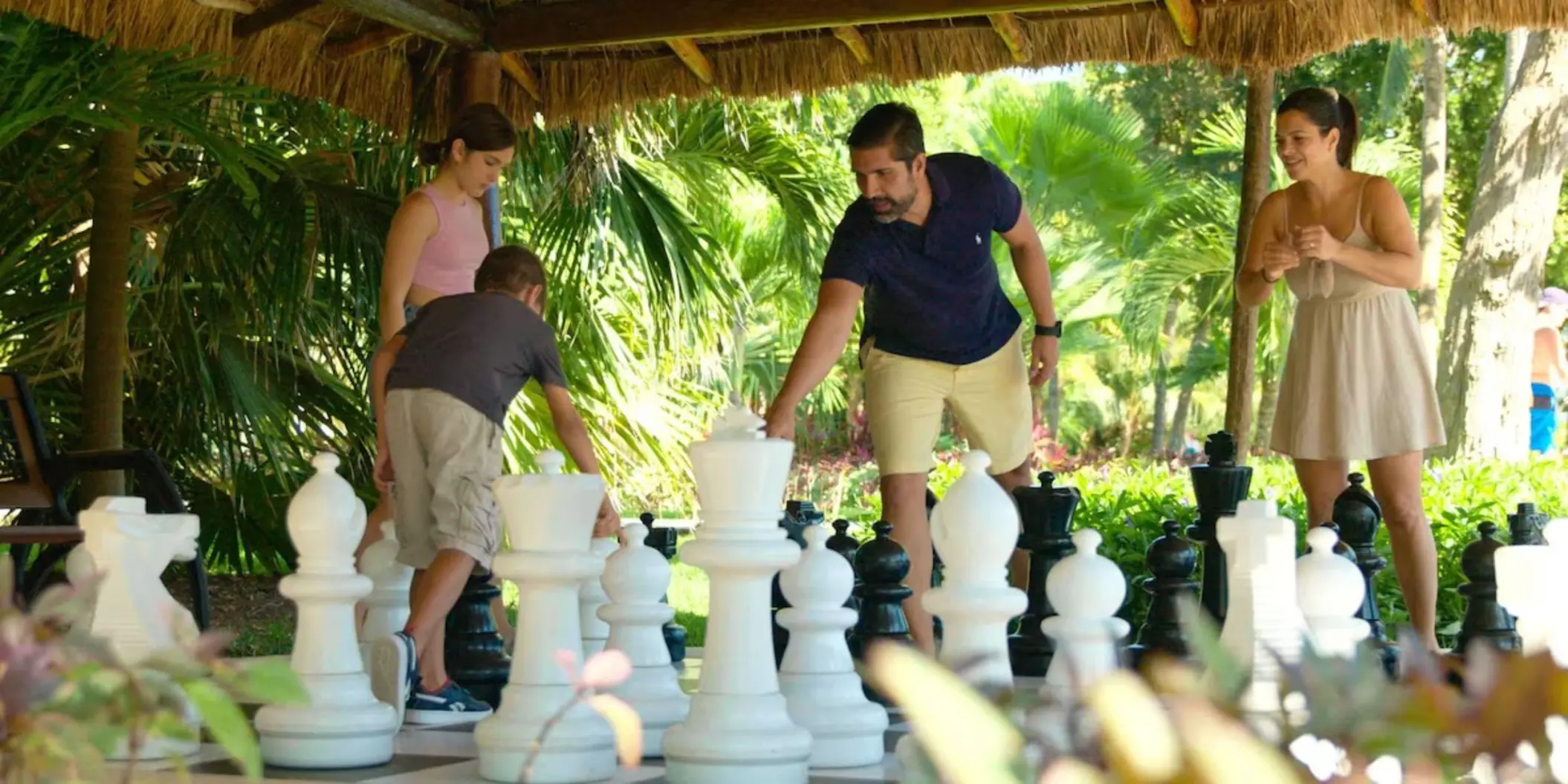family playing outdoor chess at Allegro Playacar
