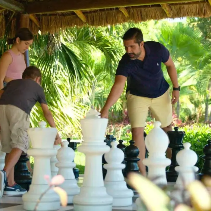 family playing outdoor chess at Allegro Playacar