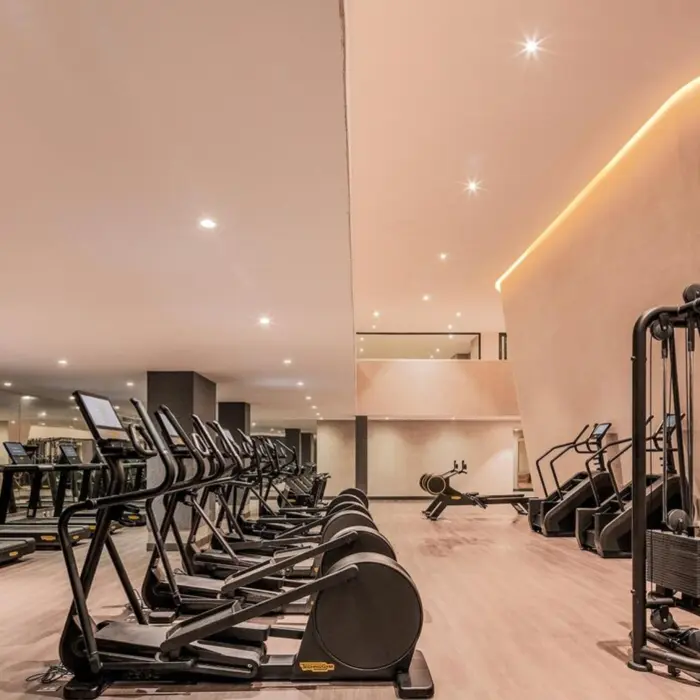 A spacious and well-equipped gym at AVA Cancun with a variety of cardio and weight machines.
