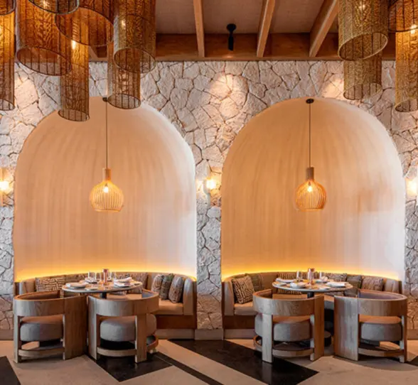 An elegant restaurant interior with unique dome-shaped seating alcoves and hanging wicker lamps.