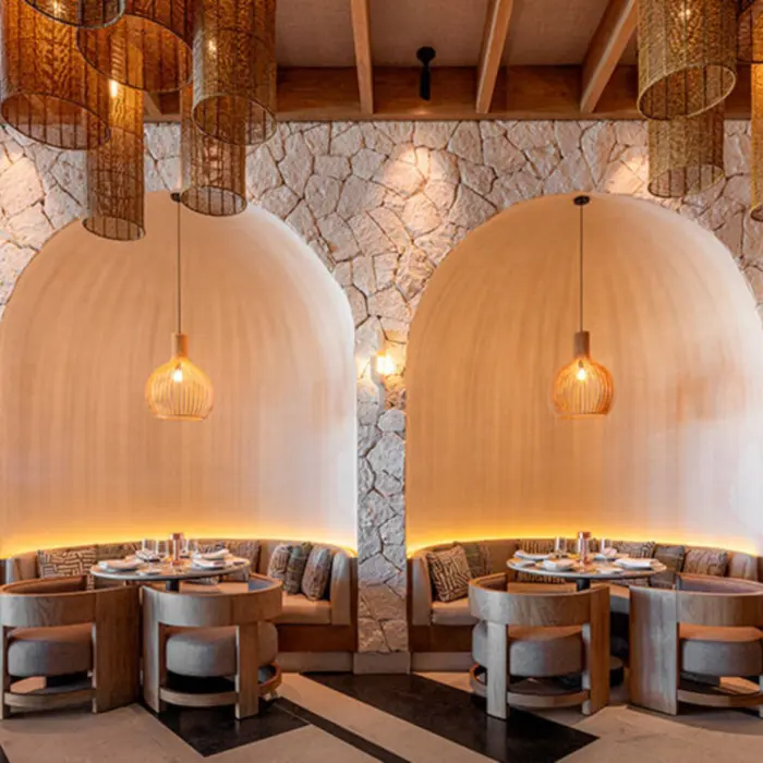 An elegant restaurant interior with unique dome-shaped seating alcoves and hanging wicker lamps.