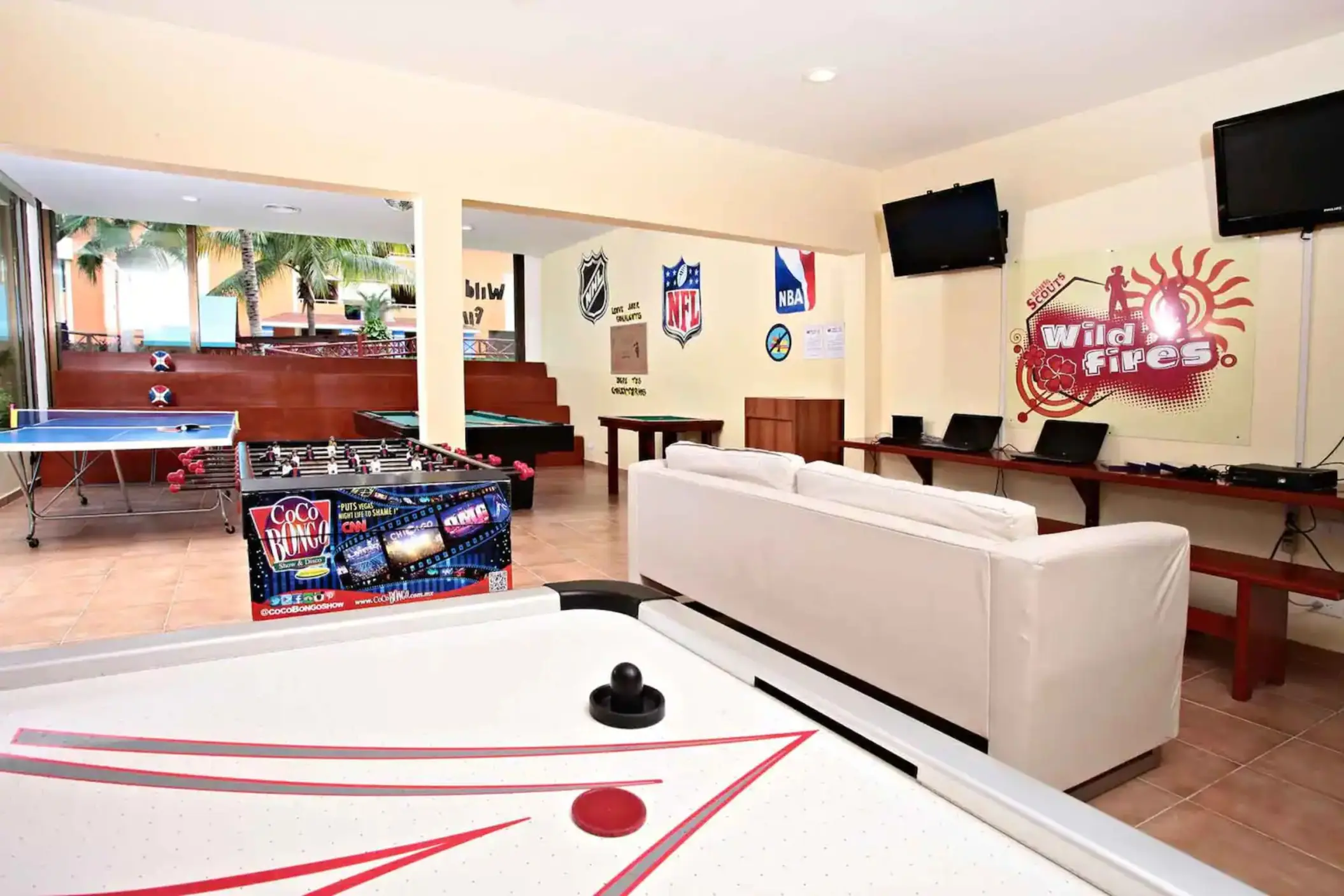 Indoor kids' play area featuring an air hockey table, foosball, and other games at Bahia Principe Grand Coba.