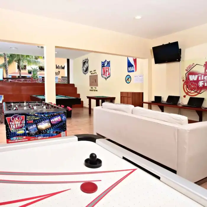 Indoor kids' play area featuring an air hockey table, foosball, and other games at Bahia Principe Grand Coba.
