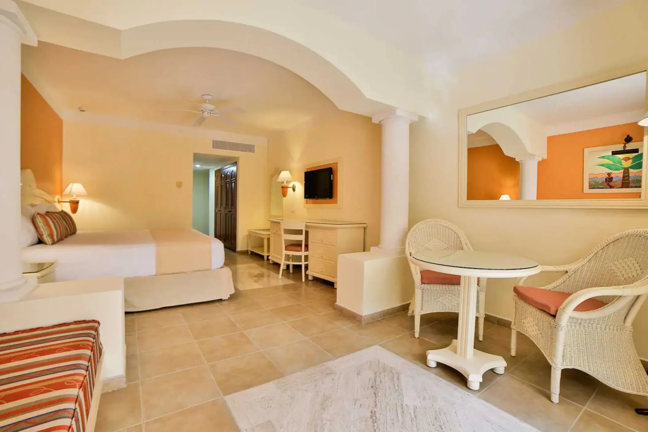 Bright and inviting suite with a comfortable bed, sitting area, and ample space at Bahia Principe Grand Coba.