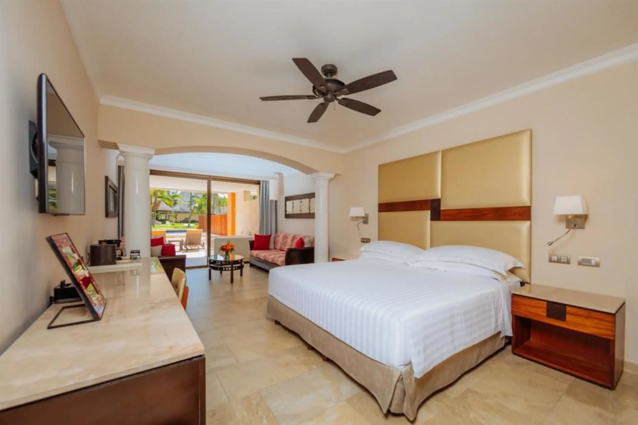 A well-appointed hotel suite featuring a comfortable king-size bed and a connected living area.