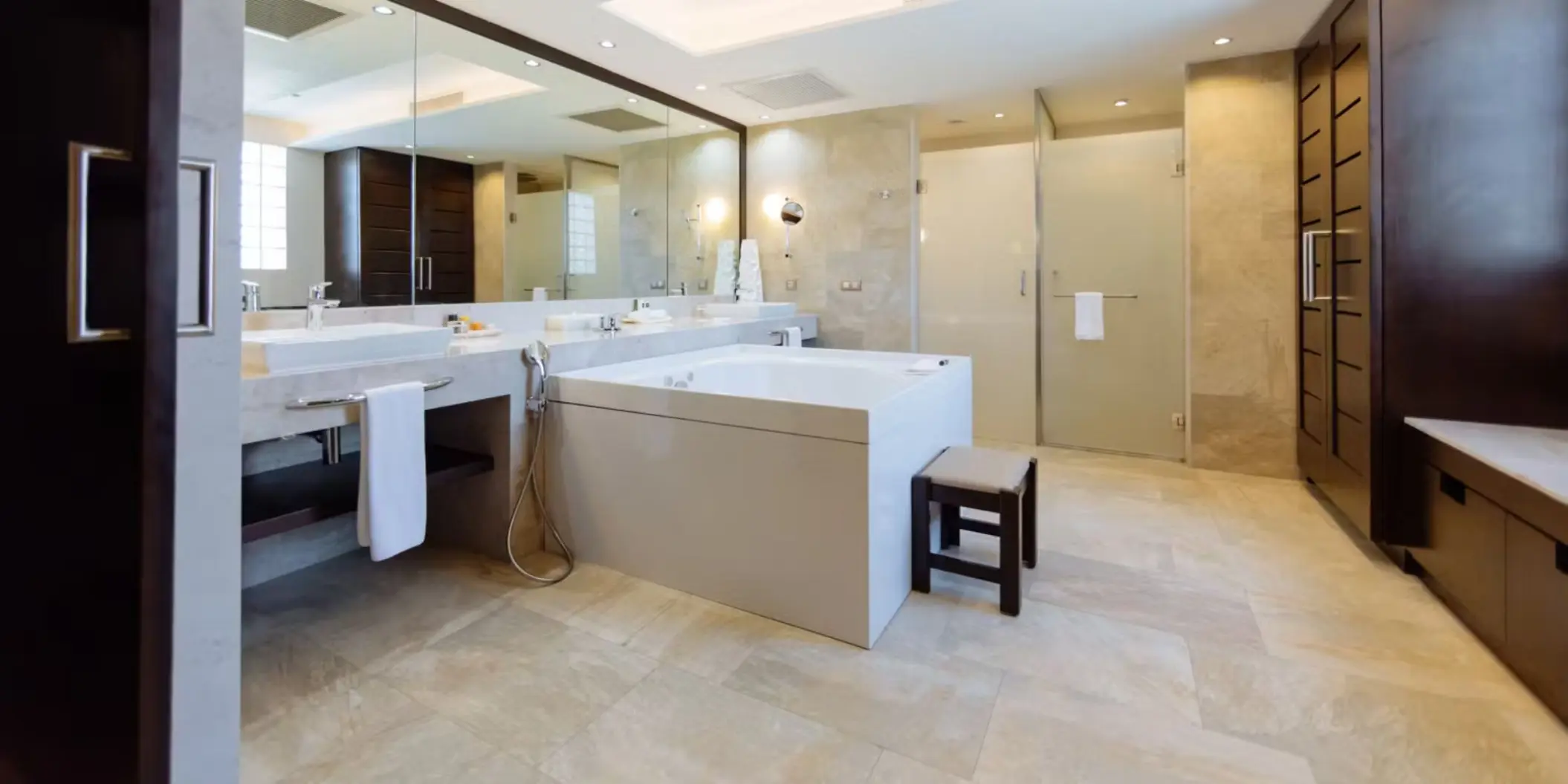A luxurious and spacious bathroom with a large bathtub, double vanity, and separate shower.