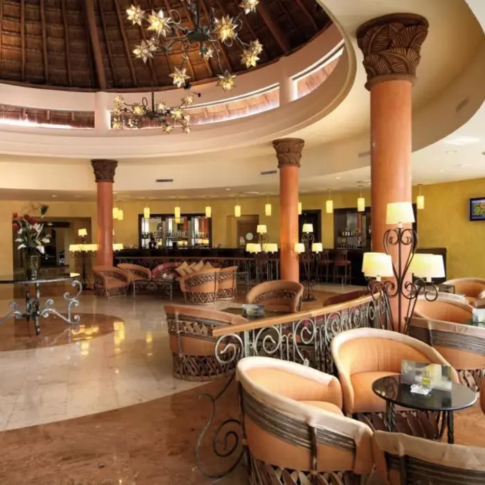 A circular lobby bar area with comfortable seating and a thatched roof, creating a tropical atmosphere.