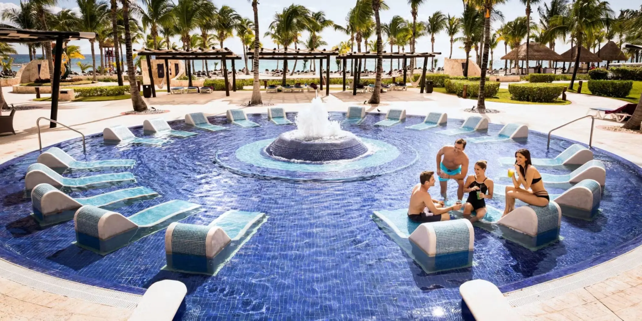 group of friends lounging in the pool at Barcelo Maya Palace