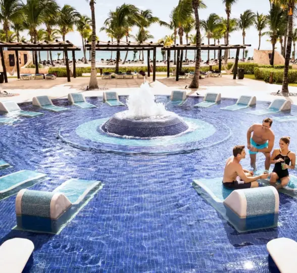 group of friends lounging in the pool at Barcelo Maya Palace