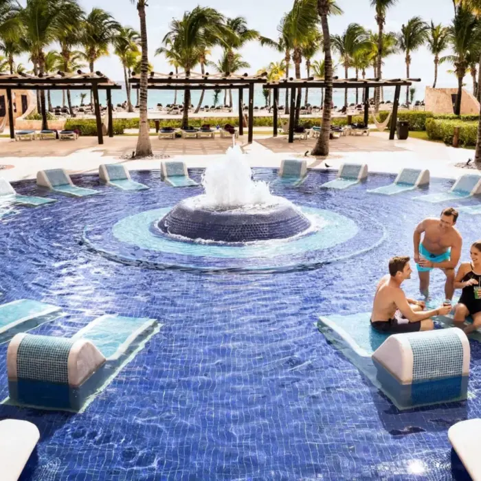 group of friends lounging in the pool at Barcelo Maya Palace