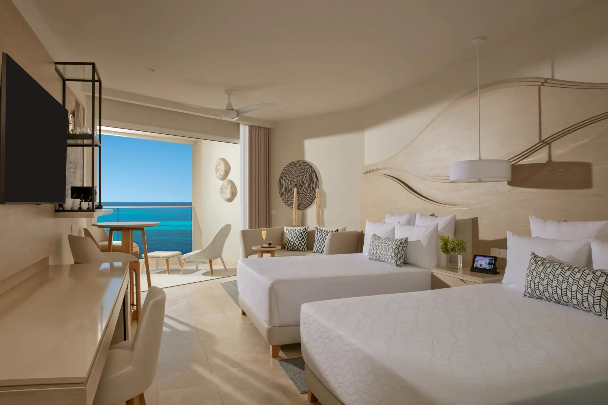 Double-bed room with ocean view balcony, warm lighting, and stylish curved wood wall design.