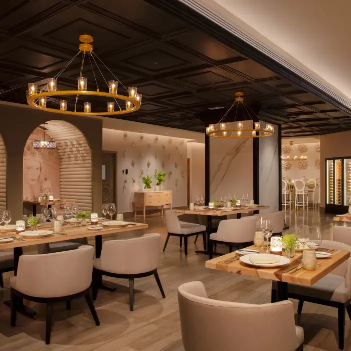 Chic French-inspired Coquette restaurant interior with warm lighting and stylish seating arrangement.