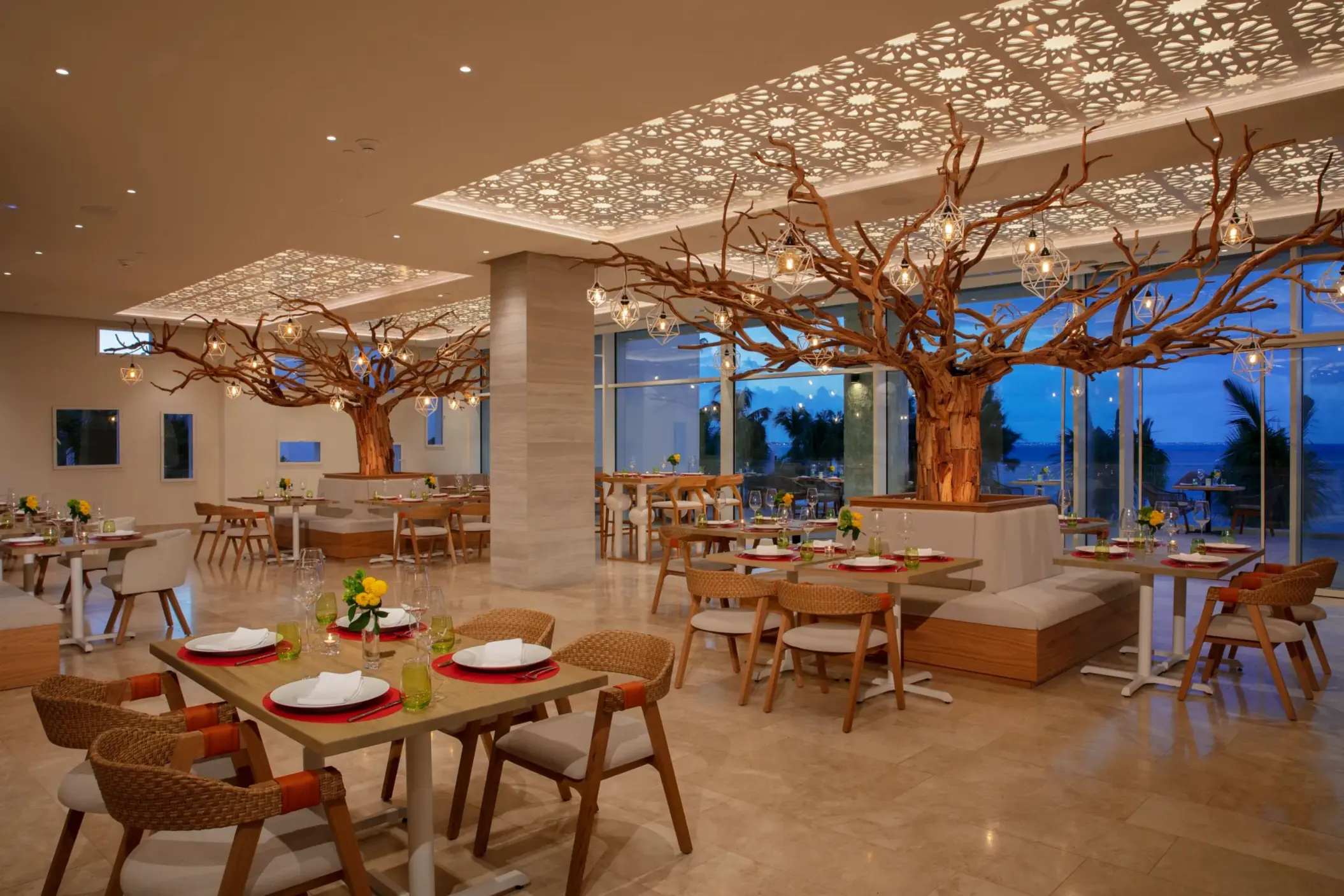 Elegant dining area at Picante restaurant featuring wood accents, tree sculptures, and ambient lighting.