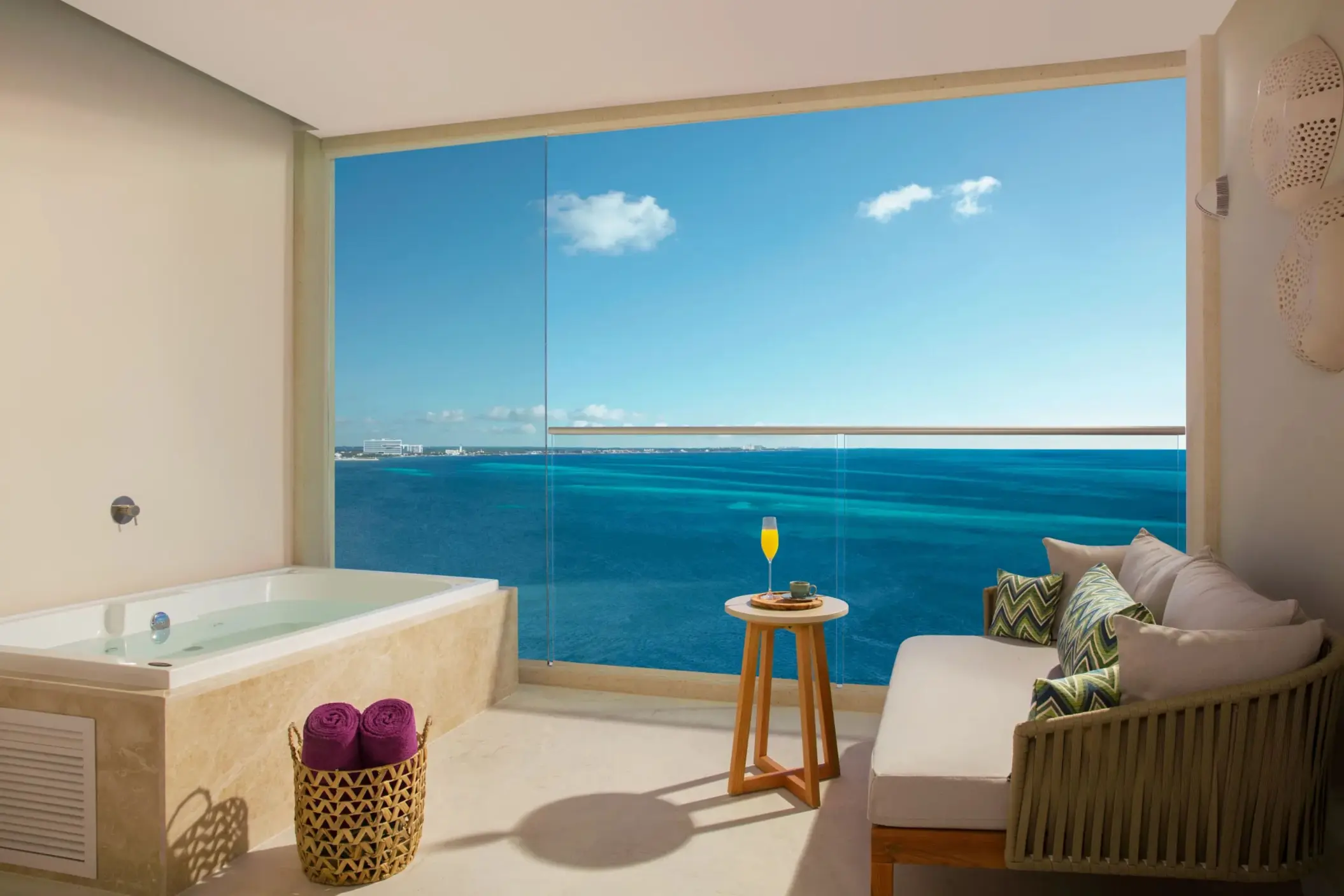 Spacious terrace suite with ocean views, private hot tub, and cozy seating area for relaxing moments.