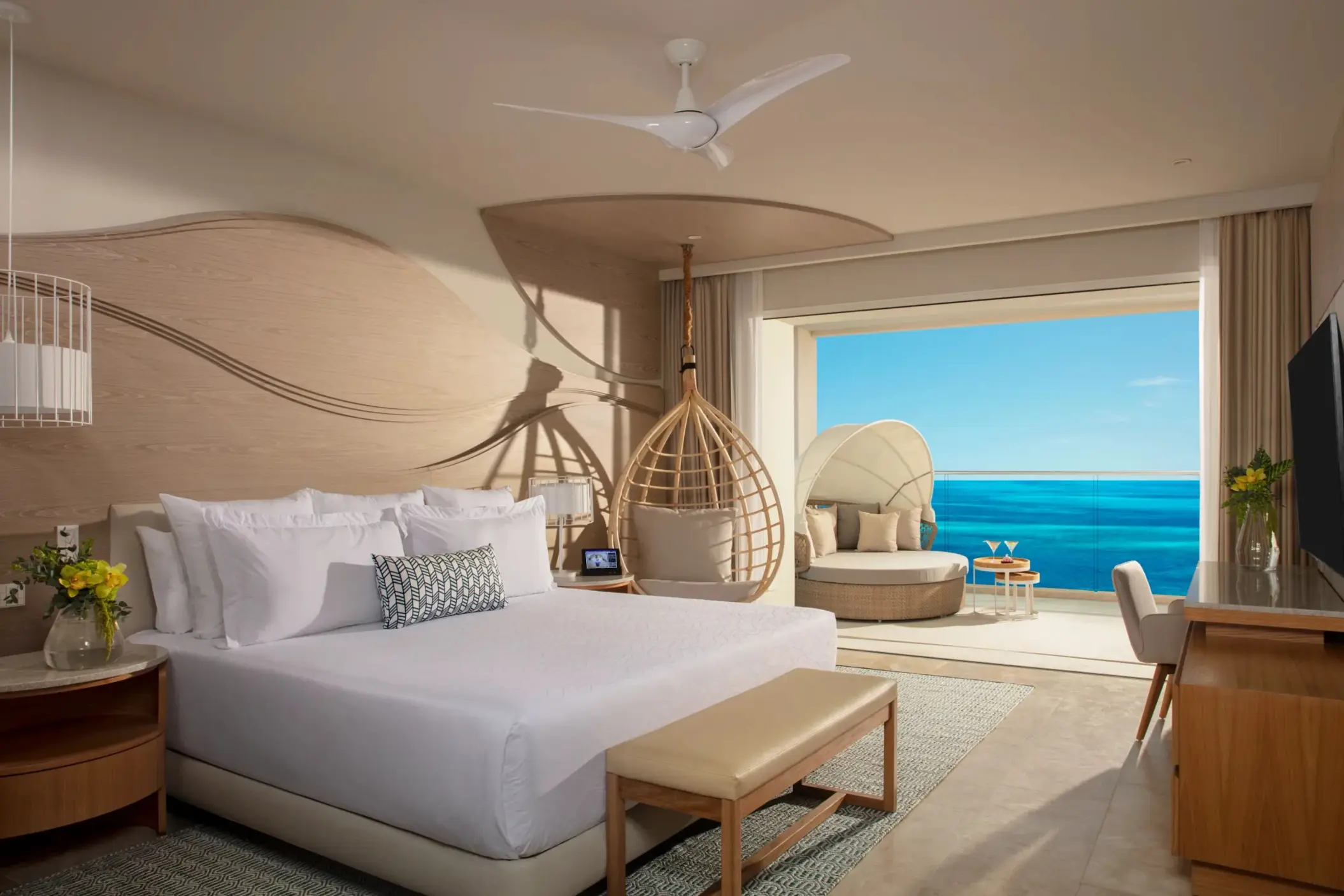 Spacious oceanview suite with king bed, hanging chair, and balcony lounge at Breathless Cancun Soul.