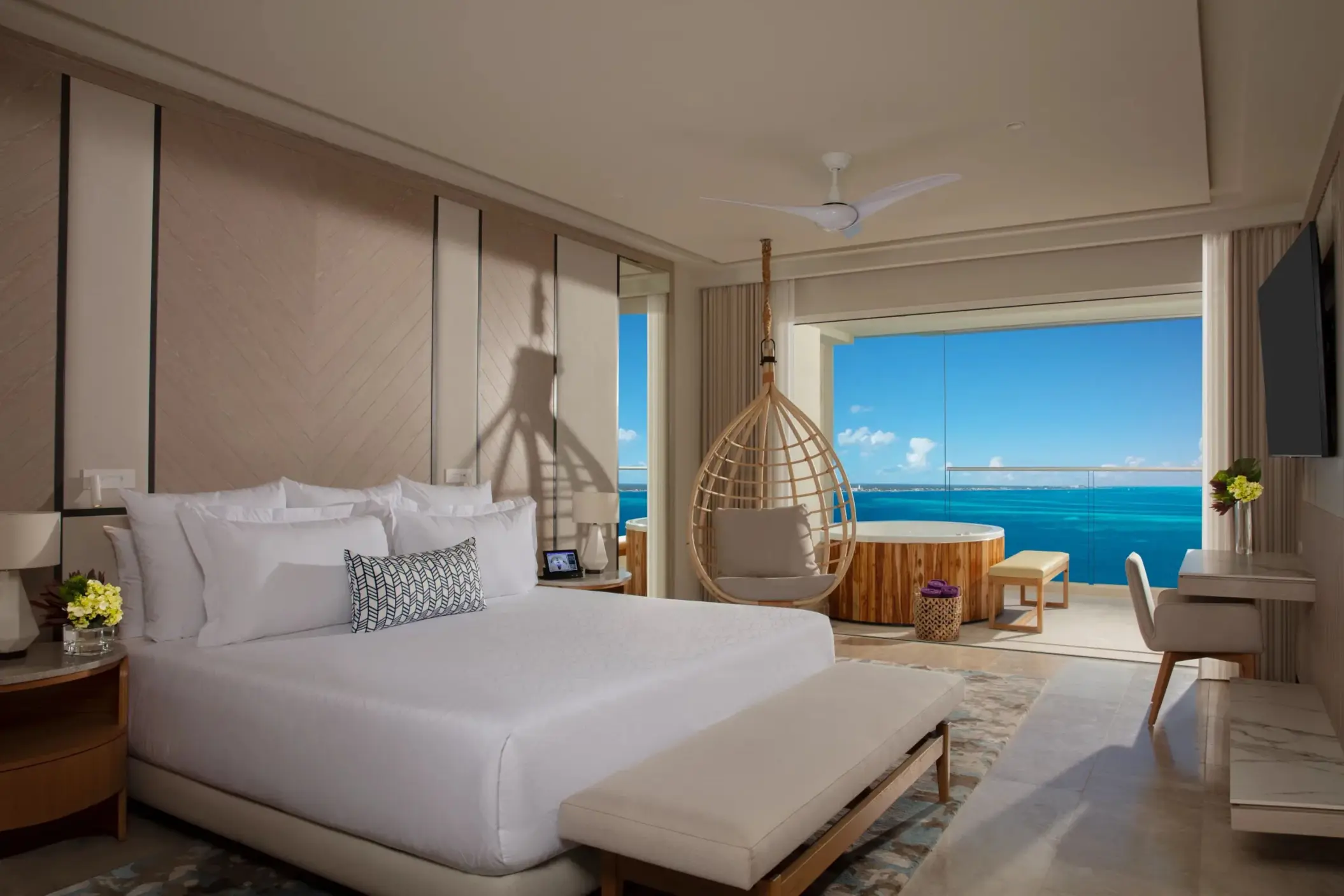 Luxurious oceanfront suite with hanging chair, king bed, and private terrace hot tub at Breathless Cancun Soul.