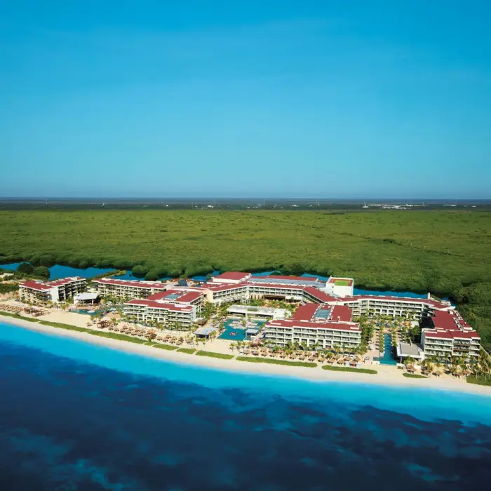Aerial view of Breathless Riviera Cancun along turquoise coastline and lush green jungle.