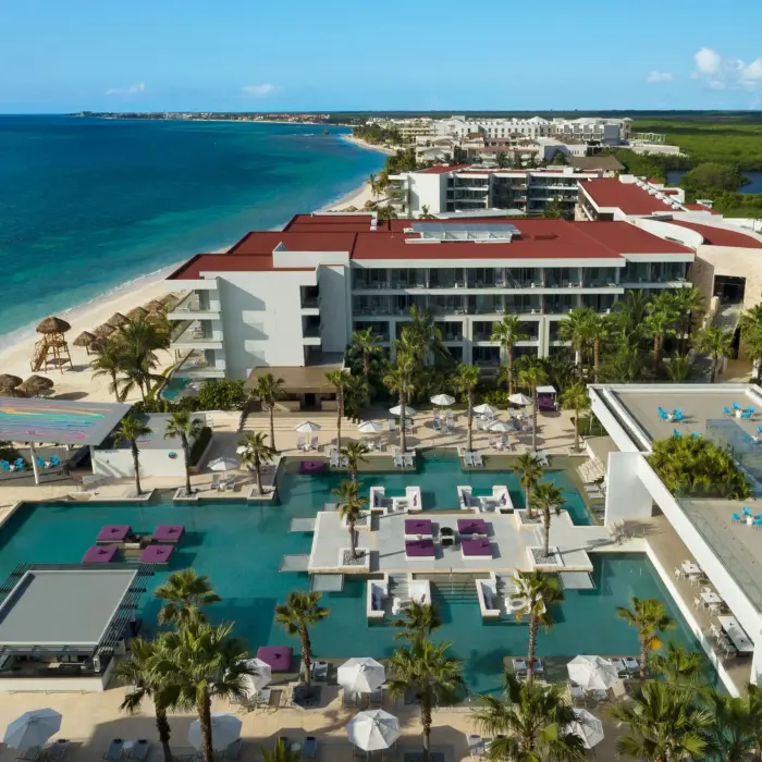 Overhead view of the lively main pool area with purple loungers and swim-up platforms.
