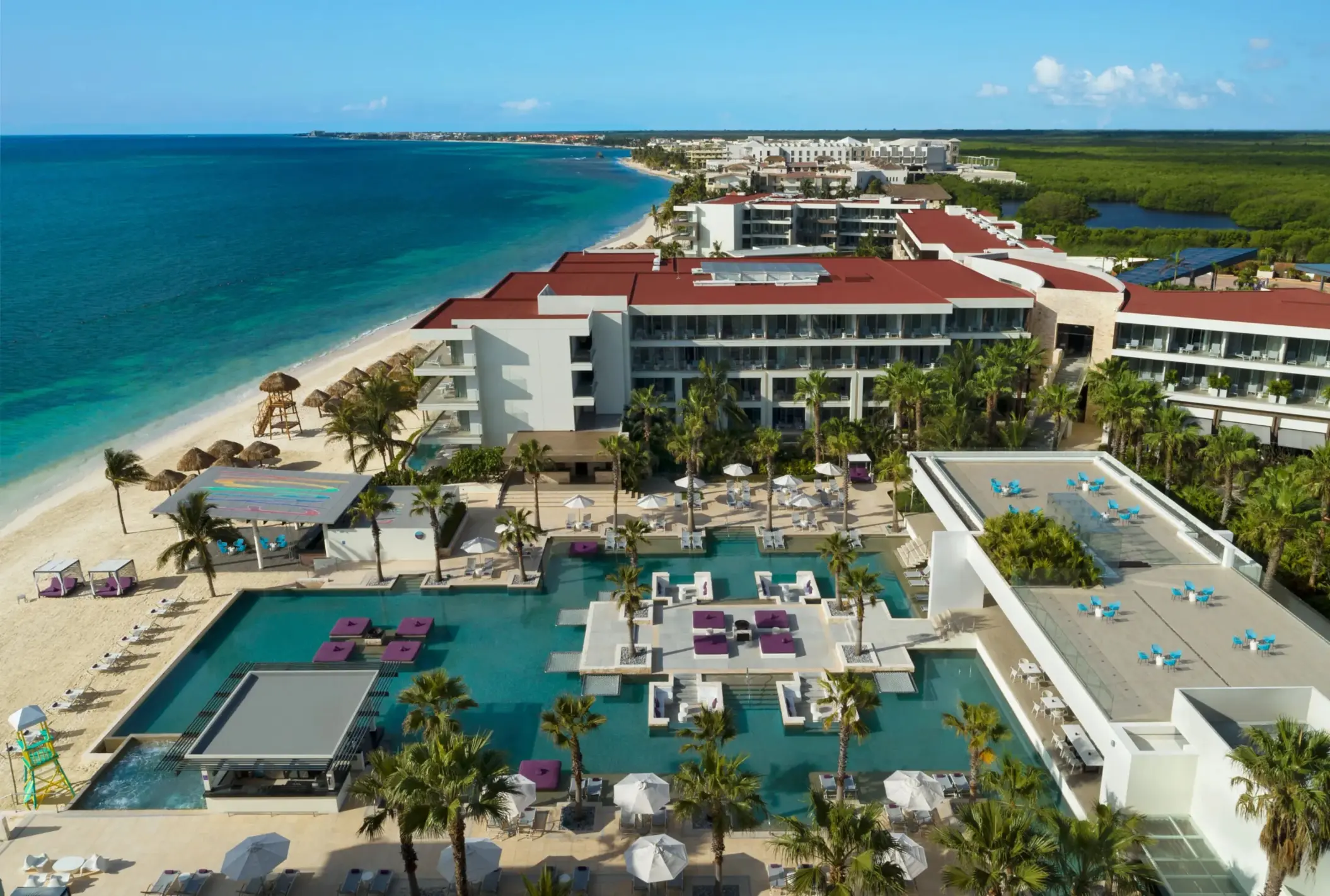 Overhead view of the lively main pool area with purple loungers and swim-up platforms.
