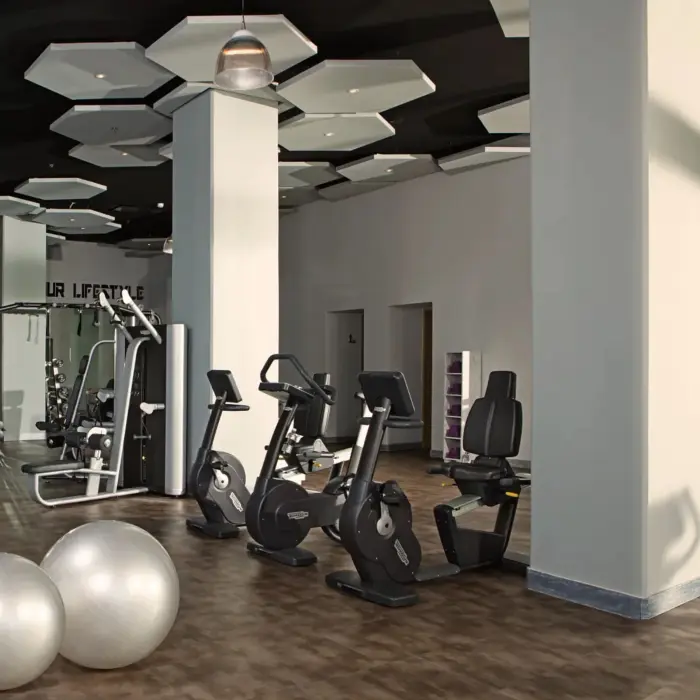Modern fitness center at Breathless Riviera Cancun with cardio machines, weights, and floor-to-ceiling windows.