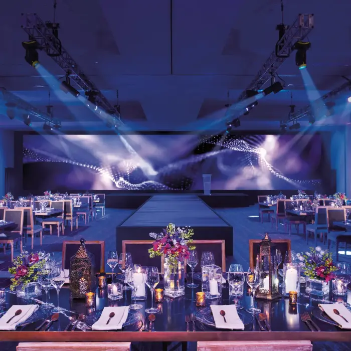 Elegant ballroom set for a gala dinner with floral centerpieces and candlelight at Breathless Riviera Cancun.