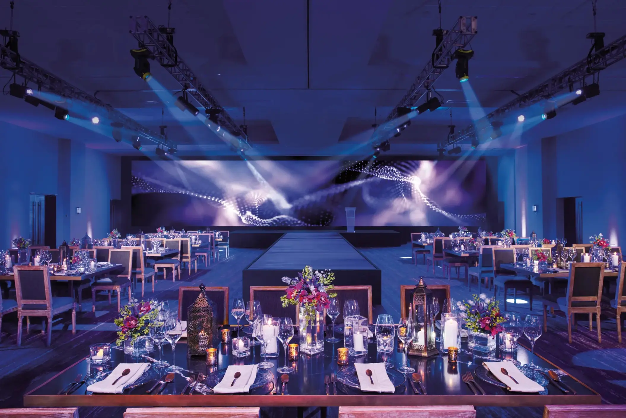 Elegant ballroom set for a gala dinner with floral centerpieces and candlelight at Breathless Riviera Cancun.