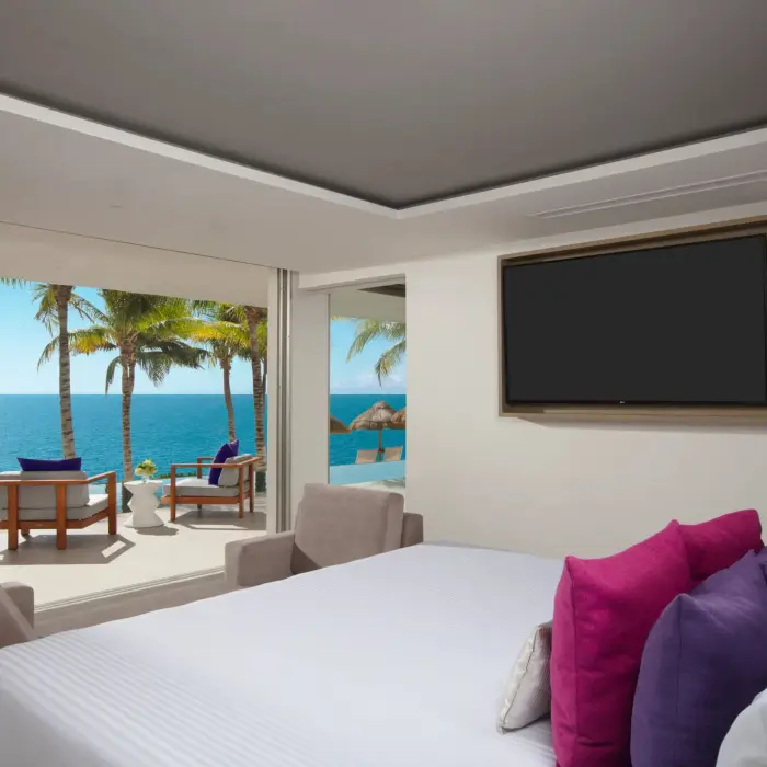 Presidential suite with ocean views, plush pillows, and direct terrace access at Breathless Riviera Cancun Resort.