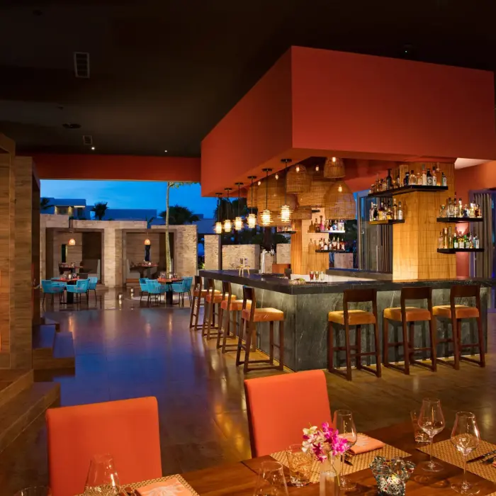 Warm, modern décor of Picante restaurant with a central bar and cozy booth seating.