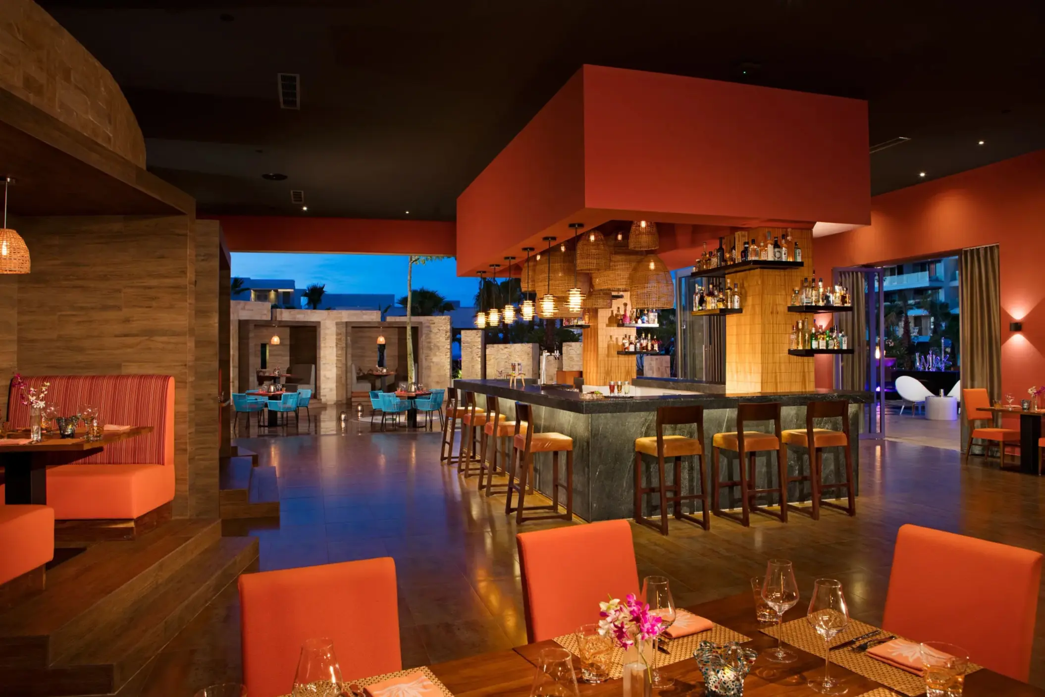 Warm, modern décor of Picante restaurant with a central bar and cozy booth seating.