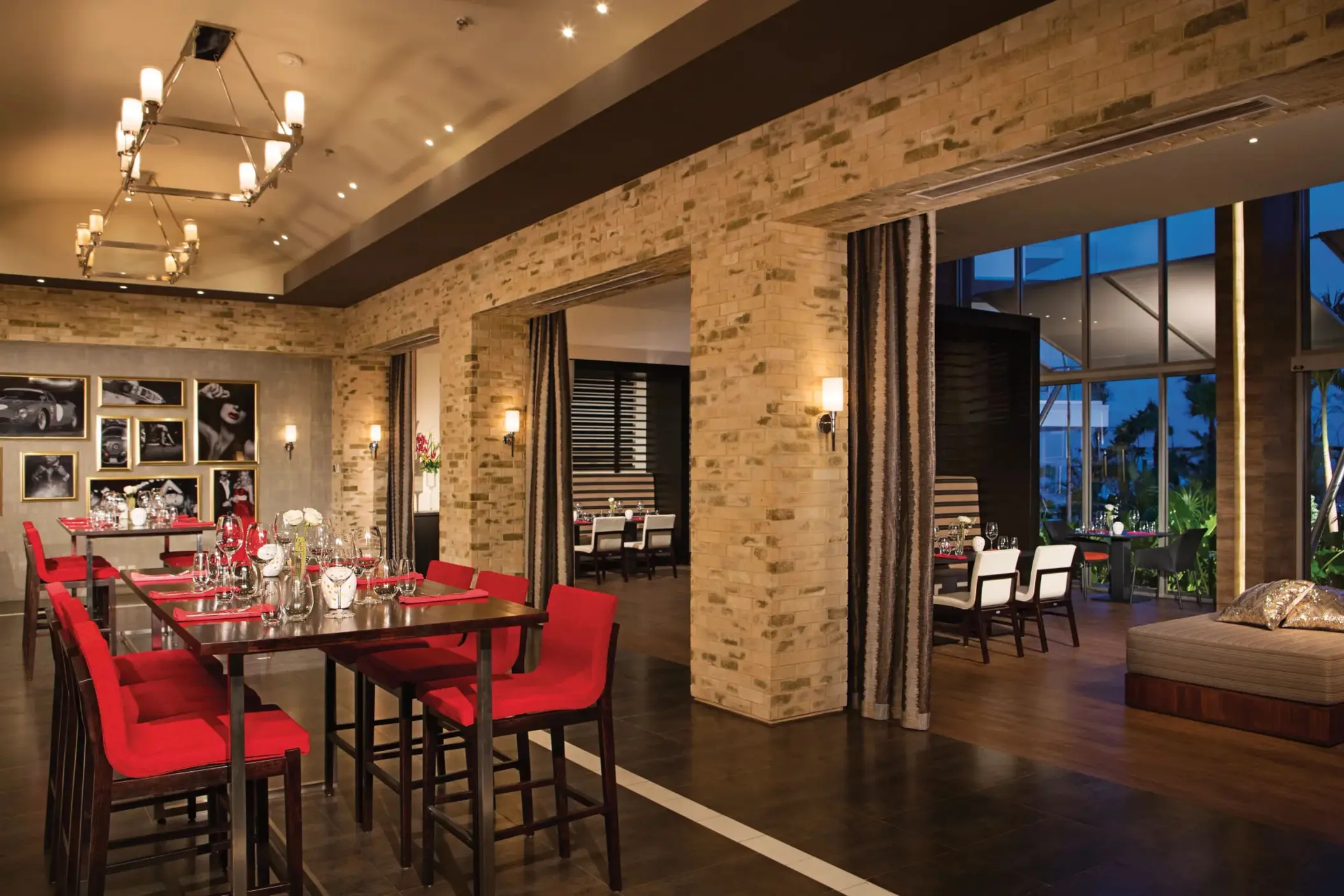 Spumante restaurant interior with brick walls, red seating, and contemporary lighting.