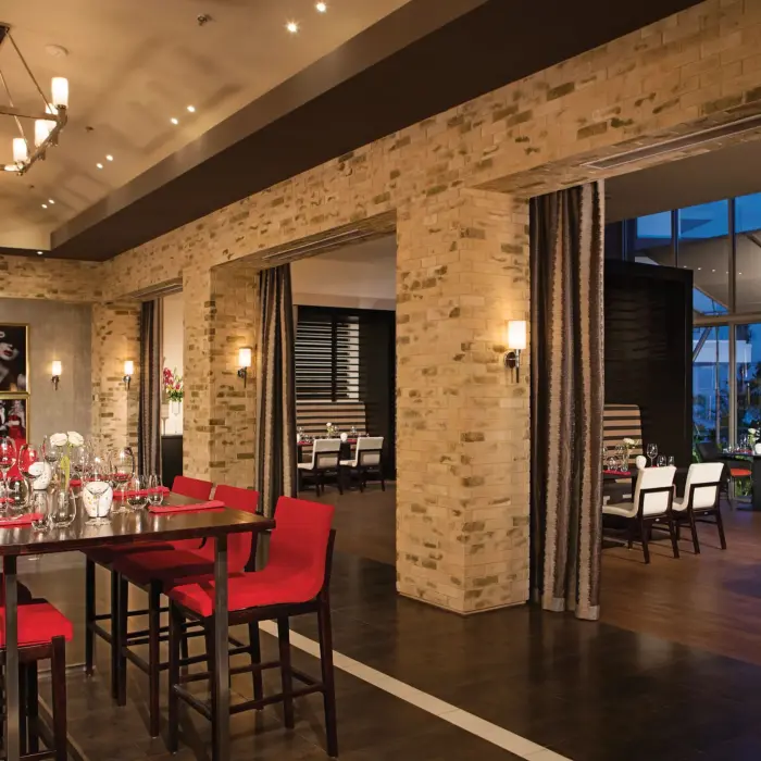 Spumante restaurant interior with brick walls, red seating, and contemporary lighting.