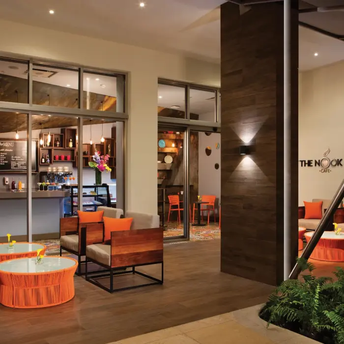 Outdoor café seating area of The Nook coffee shop with modern orange and wood furnishings.