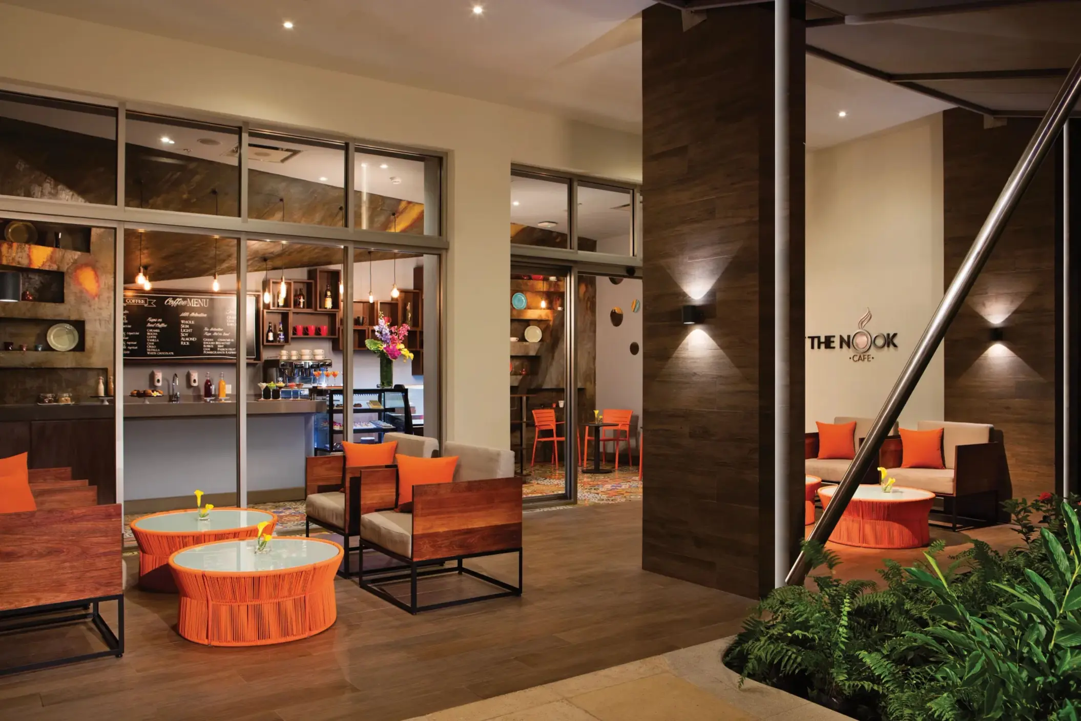 Outdoor café seating area of The Nook coffee shop with modern orange and wood furnishings.