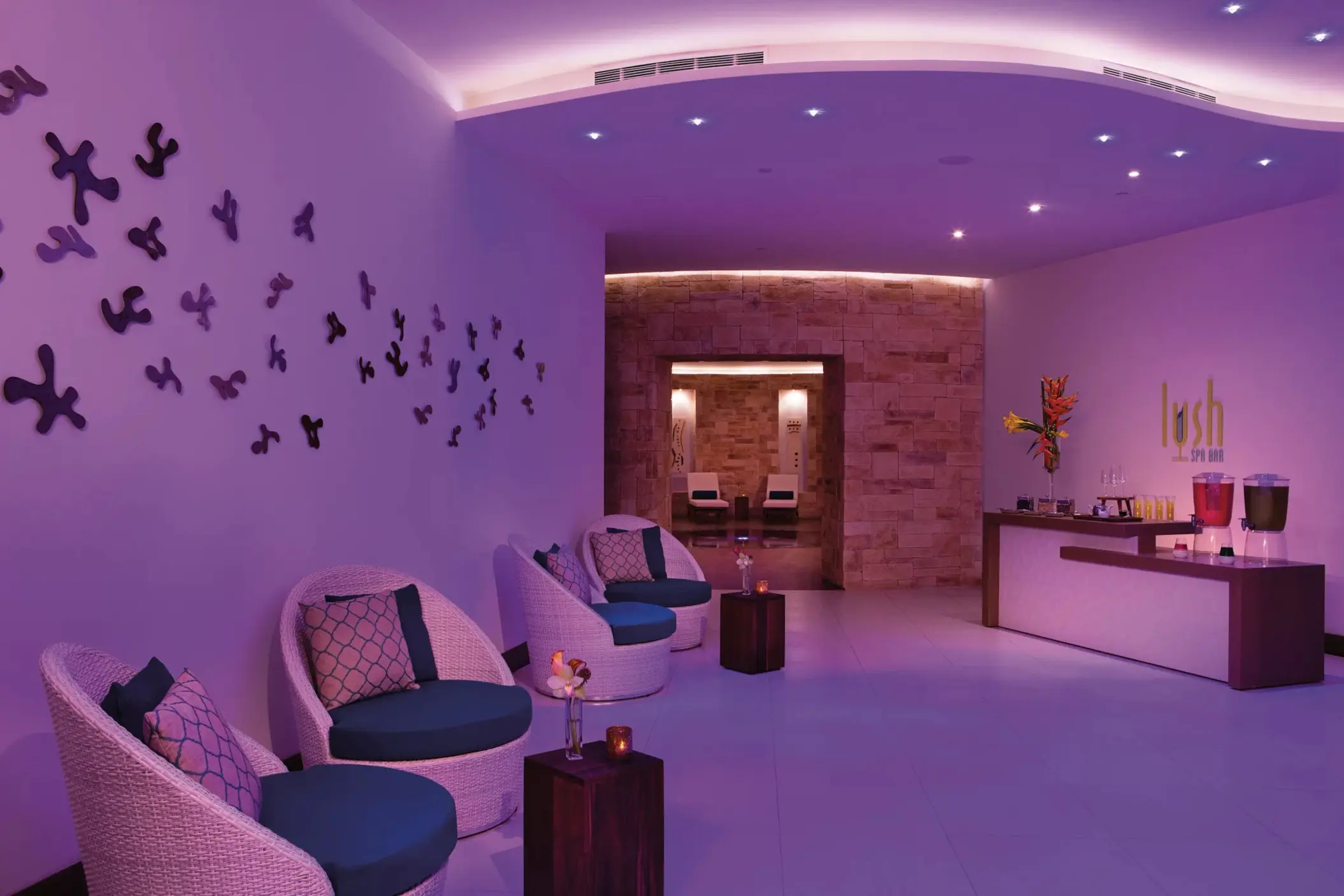 Lush Spa Bar lounge with curved lighting, refreshment station, and modern relaxation seating.
